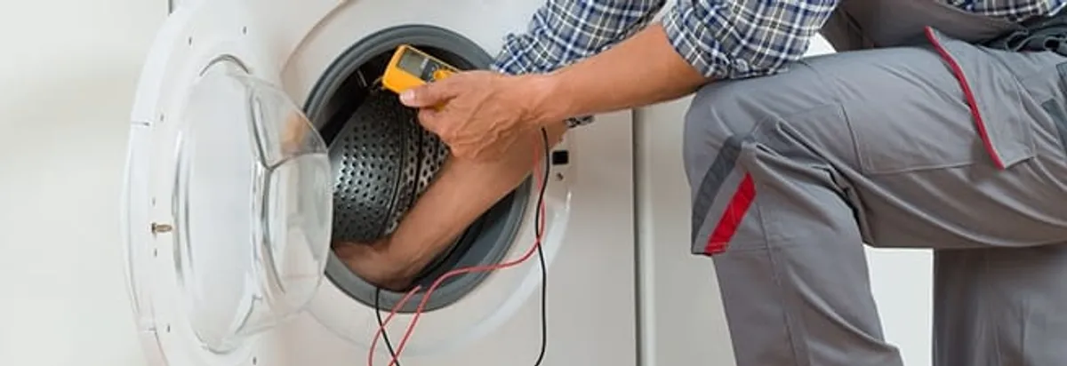 Dryer repair technician inspecting and repairing a clothes dryer in Erie, PA