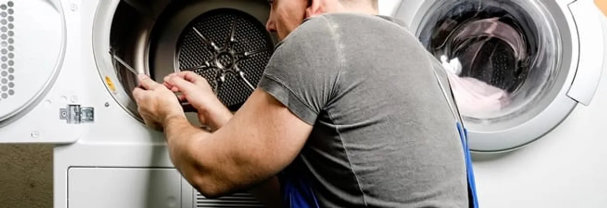 Dryer repair technician fixing a clothes dryer drum in Erie, PA