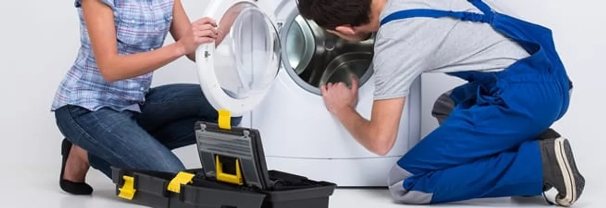 Washer repair technician inspecting a front-load washing machine with tools in Erie, PA