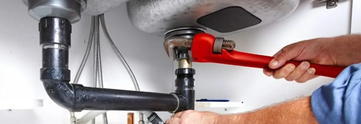 Garbage disposal repair technician tightening the sink drain and disposal connection in Erie, PA