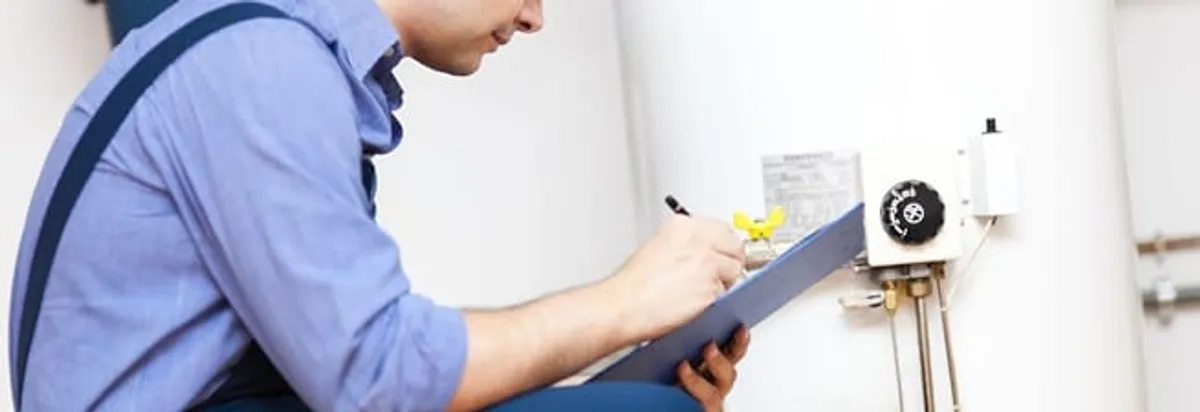 Water heater repair technician inspecting the unit and recording service notes in Erie, PA